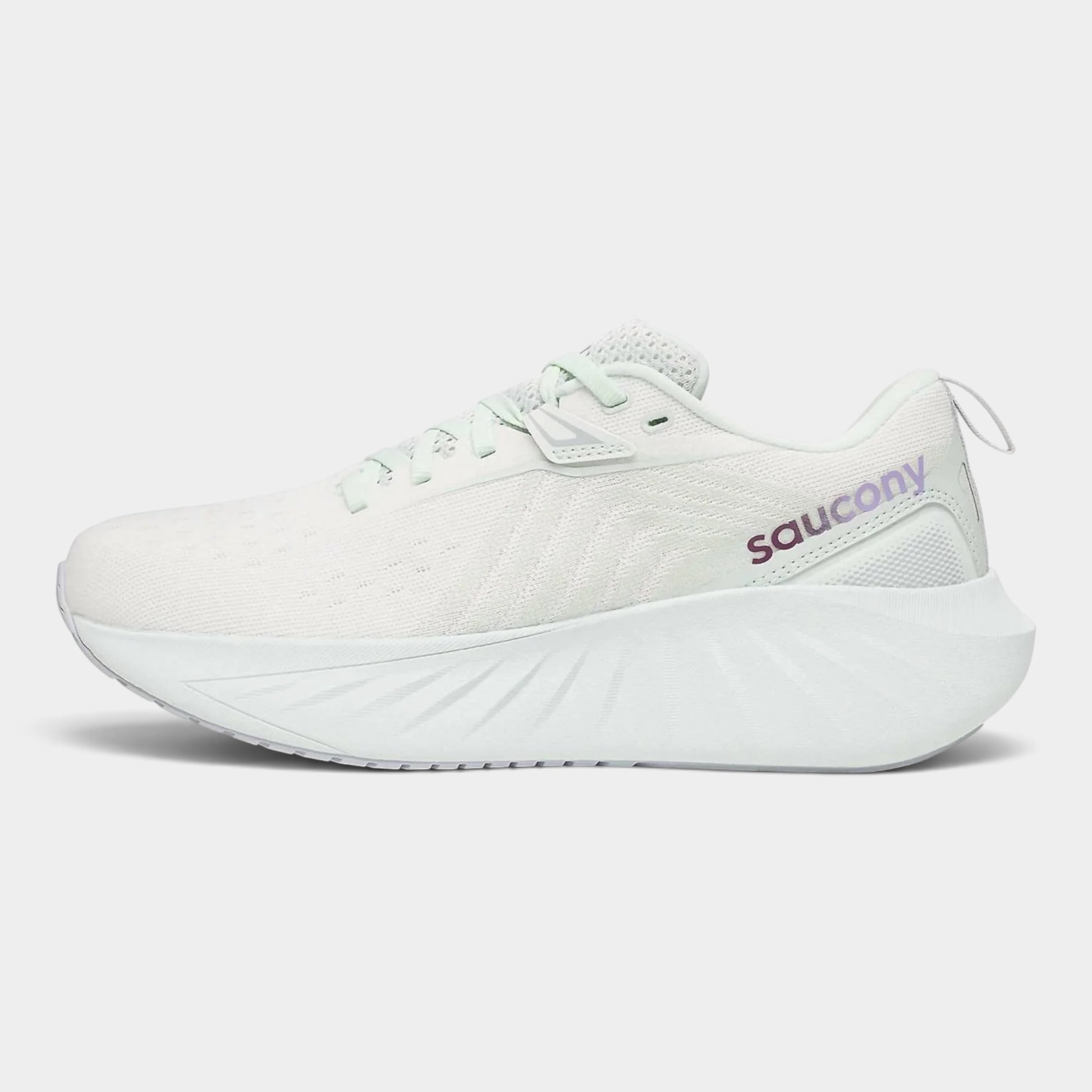A white Saucony running shoe with a textured knit upper, matching white laces, and a thick sculpted white midsole, shown from a side profile on a light gray background.
