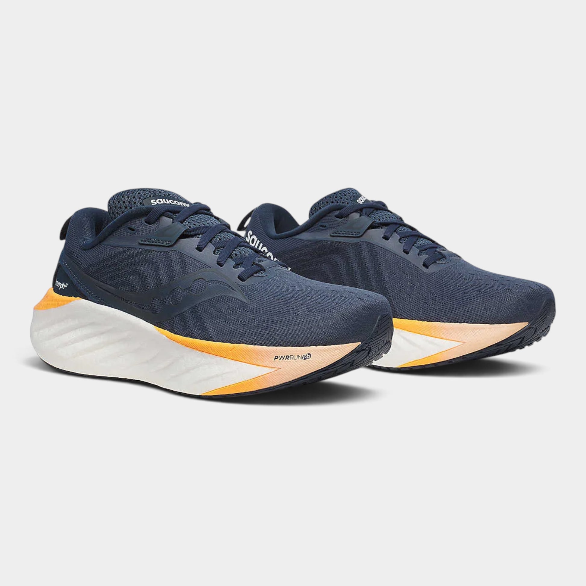A pair of Saucony running shoes in navy blue with a white midsole and orange accents, displayed on a light gray background.