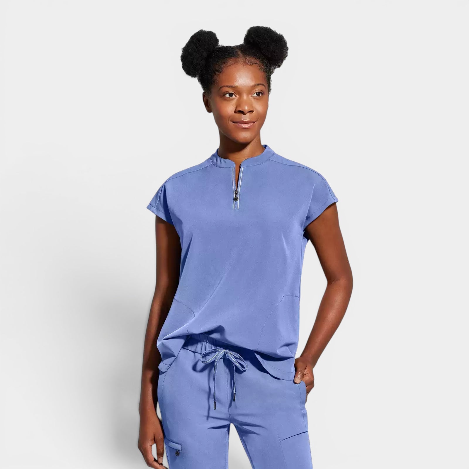 Read's Uniforms periwinkle blue relaxed fit scrub top with dolman sleeves, partial zip front, side vents, and rounded hem.