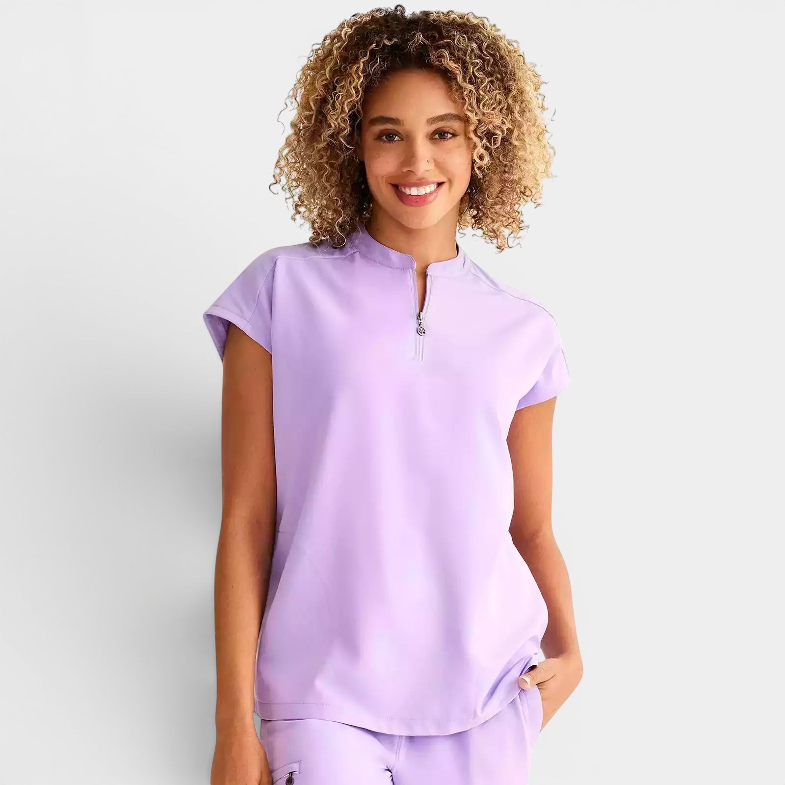 Read's Uniforms light purple relaxed fit scrub top with dolman sleeves, side vents, and partial zip front.