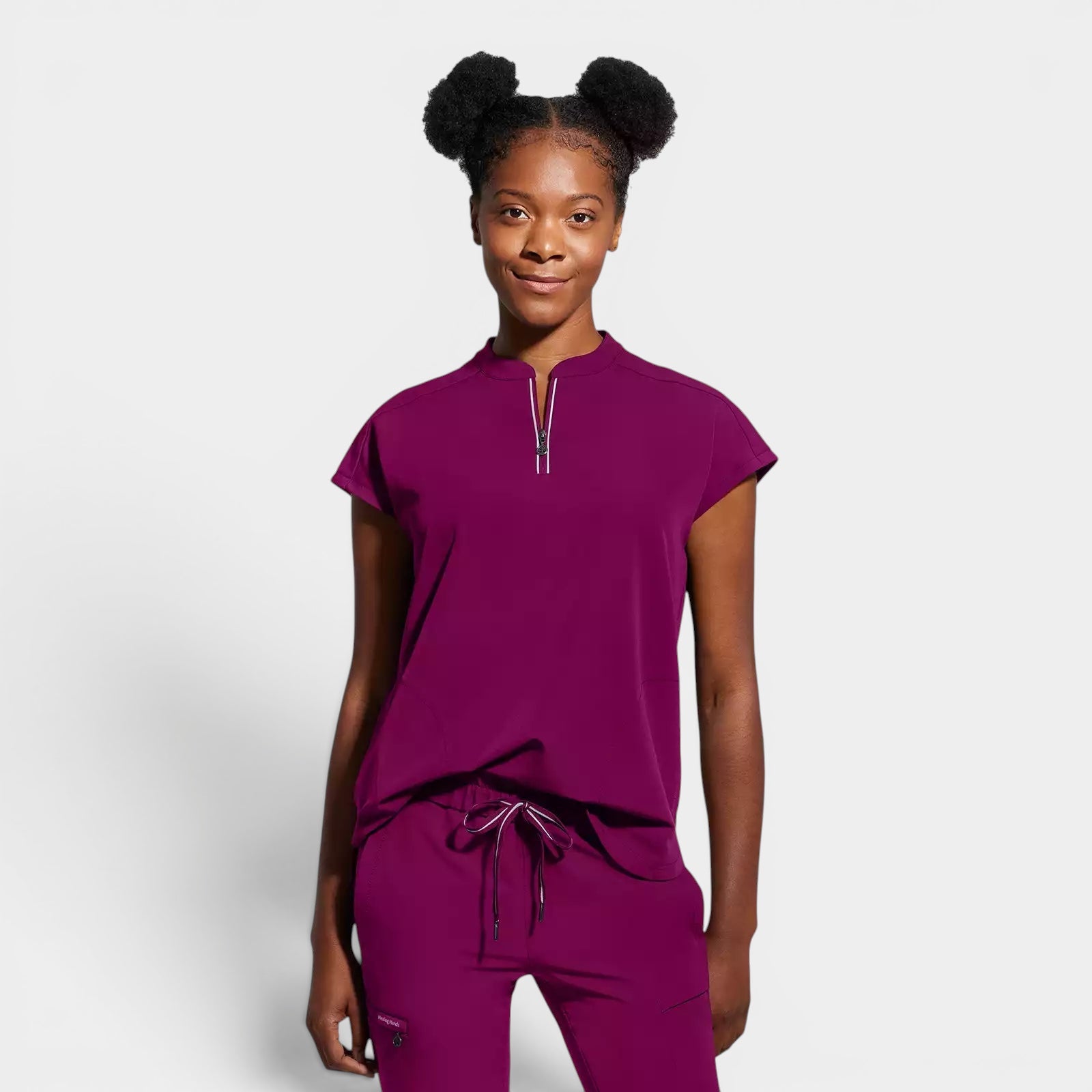 Read's Uniforms women's relaxed fit plum scrub top with dolman sleeves, partial zip front, side vents, and rounded hem.