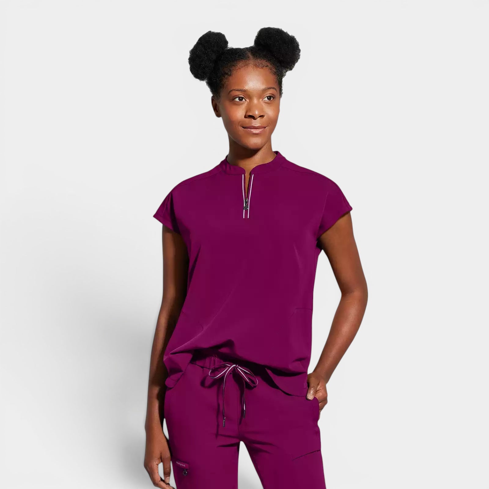 Read's Uniforms plum purple scrub top with dolman sleeves, partial zip front, rounded hem, and two welt pockets.